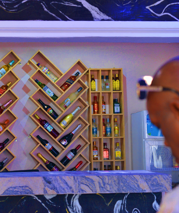 Interior view of the Inner Bar at Gladben Hotel with stylish seating, warm lighting, and a stocked bar.