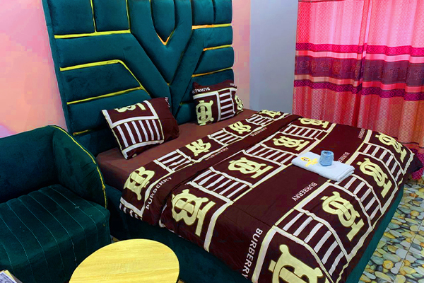 Luxuriously furnished guest room at Gladben Exclusive Hotel with plush bedding and modern amenities.