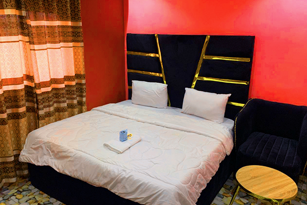 Luxuriously furnished guest room at Gladben Exclusive Hotel with plush bedding and modern amenities.